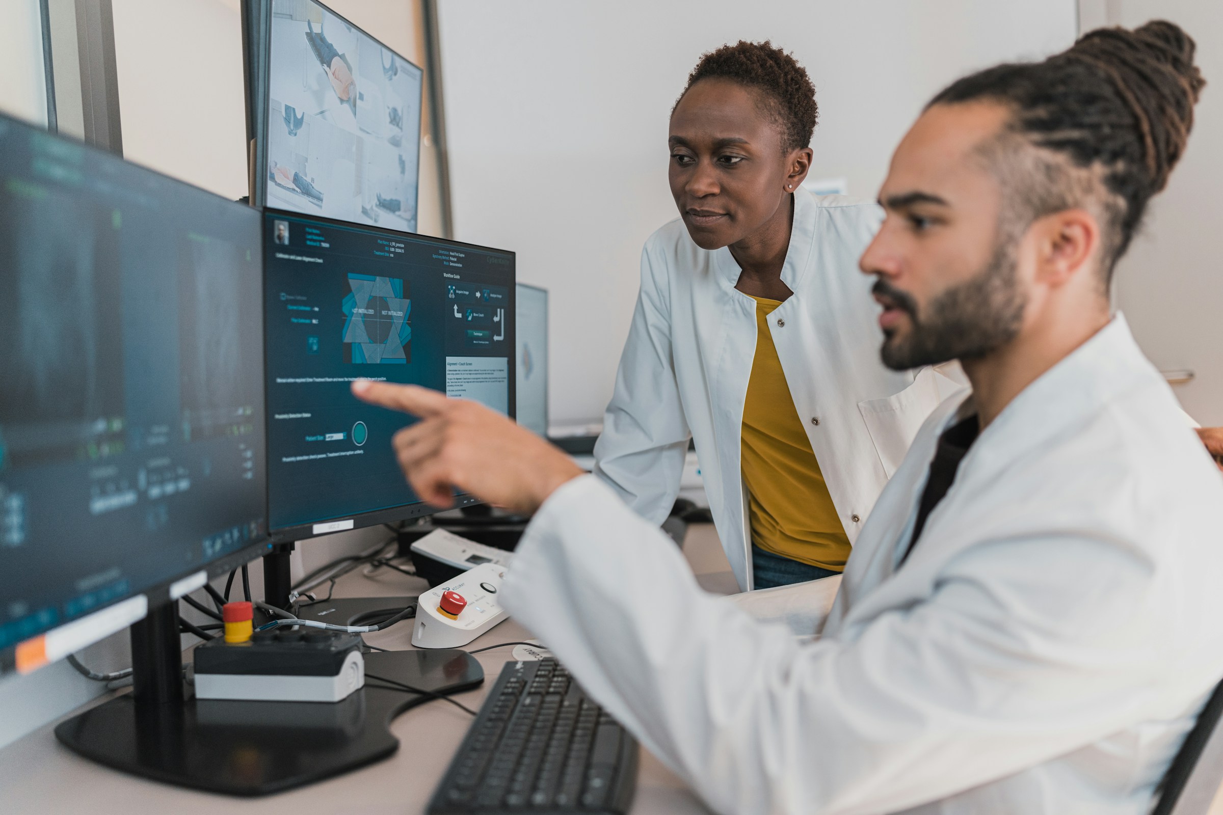 Two providers look at a computer. Photo by Accuray on Unsplash